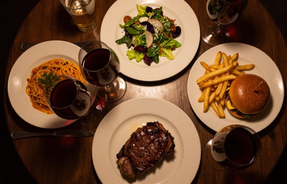 Four different meals on a restaurant table seen from above