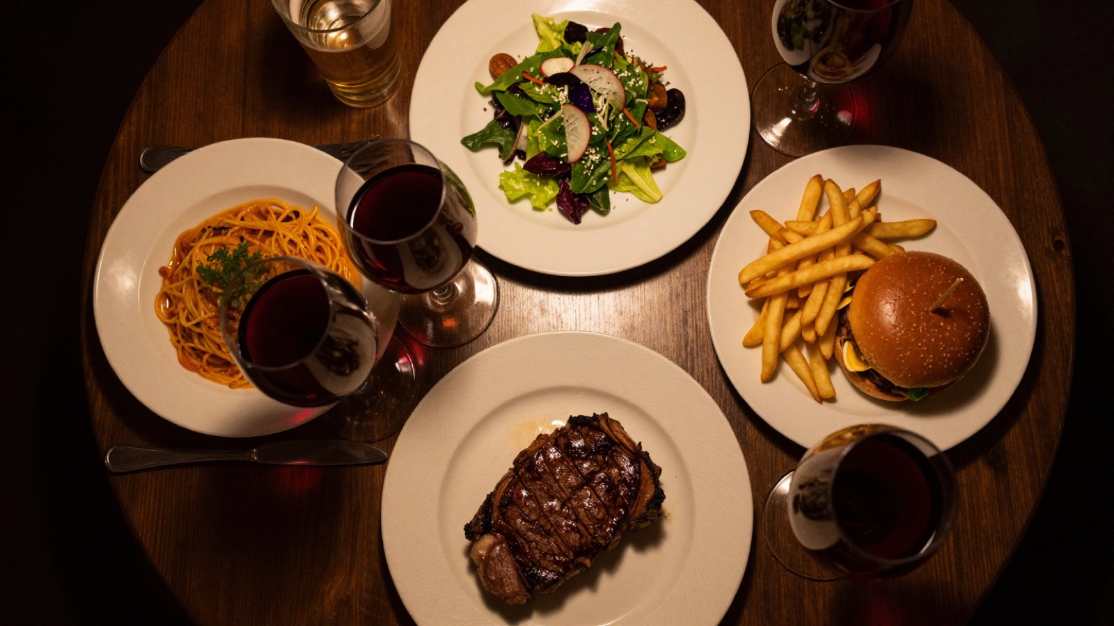 Four different meals on a restaurant table seen from above